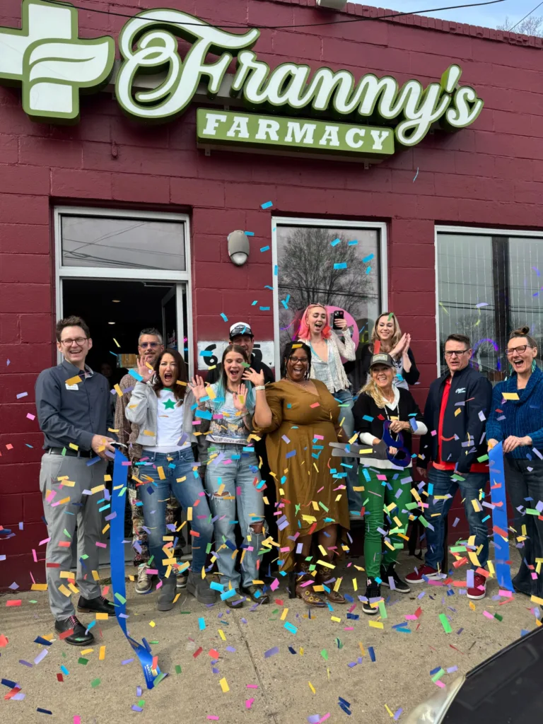 Franny's Farmacy team celebrating a store grand opening with confetti and a ribbon-cutting